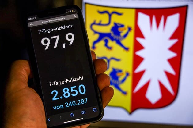 Coronavirus in Germany Covid 19 Dashboard of the Robert Koch Institute DEU, Germany, Schleswig Holstein 14 11 2021 The 7-day incidence for the state Cases last 7 days 100 000 PE is displayed on an iPhone, with the state coat of arms in the background.