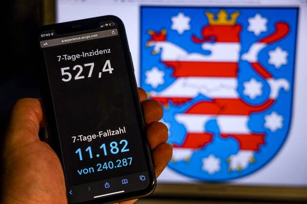 Coronavirus in Germany Covid 19 Dashboard of the Robert Koch Institute DEU, Germany, Thuringia 14 11 2021 The 7-day incidence for the state Cases last 7 days 100 000 p.e. is displayed on an iPhone, with the state coat of arms in the background