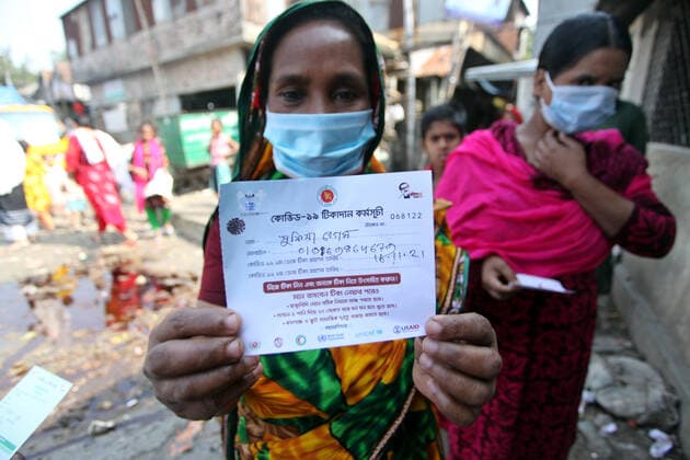 Covid-19 Vaccination Campaign For Inhabitants Of Korail DHAKA, BANGLADESH - NOVEMBER 16, 2021: A woman shows vaccination certificate while she queue during the national vaccination program promoted by the government to Korail inhabitants as an attempt to avoid the Covid-19 disease infection, the government began administering the coronavirus vaccine dose to the inhabitants of the city s slums. On November 16, 2021 in Dhaka, Bangladesh. (Photo by Habibur Rahman Eyepix Group) Copyright: xHabiburxRahmanx EYEPIXGROUP_HR_16112021_19502