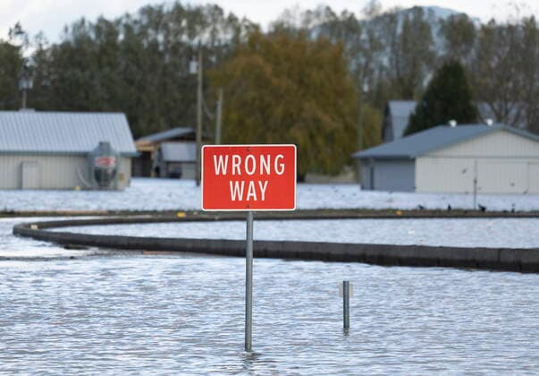 November 16, 2021, CHILLIWACK, BC, CANADA: A road sign is surrounded by flood waters as a farm is pictured in the background in Chilliwack, B.C., Tuesday, November 16, 2021. CHILLIWACK CANADA  - ZUMAc35_ 20211116_zaf_c35_030 Copyright: xJonathanxHaywardx
