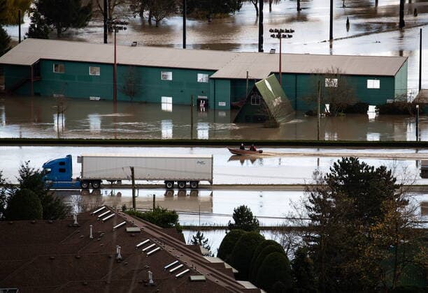 November 16, 2021, ABBOTSFORD, BC, CANADA: People in a boat travel along the Trans-Canada Highway past an abandoned transport truck and trailer in a flooded area of Abbotsford, B.C., on Tuesday, November 16, 2021. ABBOTSFORD CANADA  - ZUMAc35_ 20211116_zaf_c35_066 Copyright: xDarrylxDyckx