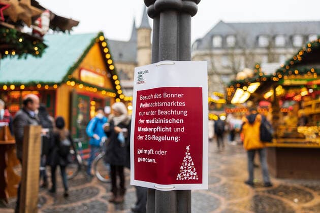 Sign of the city of Bonn with the inscription Besuch des Weihnachtsmarktes nur unter Beachtung der medizinischen Maskenpflicht und der 2G Regelung geimpft oder genesen Opening day of the Christmas market 2021 on the Münsterplatz in Bonn 17 10 2021 Bonn Innenstadt NRW Germany