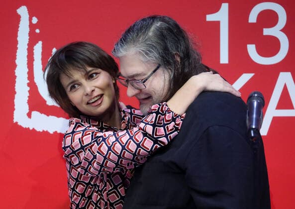 MOSCOW, RUSSIA - NOVEMBER 17, 2021: Russian visual artist Anatoly Osmolovsky (R) and Albina Mokhryakova, winner of the Young Artist. Project of the Year nomination for her Swarm video, embrace during a ceremony to present the 2021 Kandinsky Prize at the Museum of Modern Art. Sergei Fadeichev TASS  TS118407