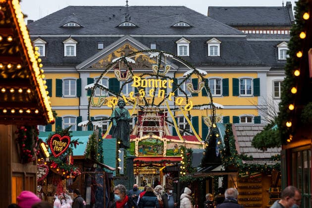 The monument of Ludwig van Beethoven in front of the Bonn Ferris wheel on the Münsterplatz The Bonn Christmas market in the shadow of the Corona pandemic The 2G rule vaccinated or recovered also applies in the inner city area the mask obligation 19 11 2021 Bonn city centre NRW Germany