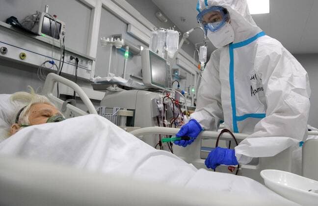Russia Coronavirus Treatment 6700052 19.11.2021 A medical specialist wearing protective gear treats a patient at an intensive care ward at a pavilion of the Exhibition of Achievements of National Economy (VDNH), which was converted into a reserve hospital for people suffering from the coronavirus disease, in Moscow, Russia. Ilya Pitalev Sputnik Moscow Russia  Copyright: xIlyaxPitalevx
