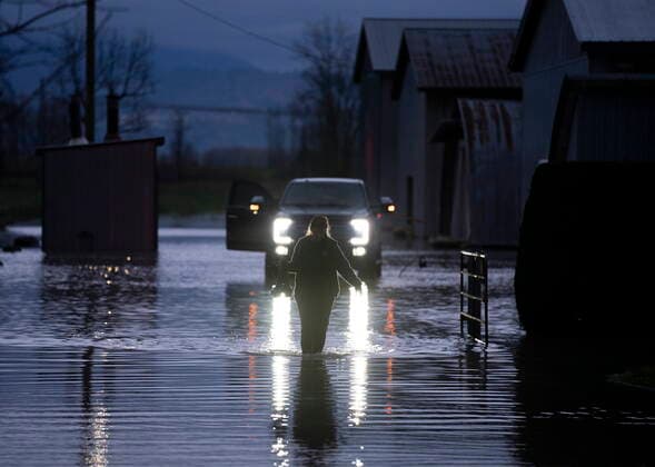 November 19, 2021, ABBOTSFORD, BC, CANADA: Sara Dejong is silhouetted by the headlights of a truck as she walks through flood waters after bringing her husband some food in Barrowtown near Abbotsford, B.C., Friday, November 19, 2021. ABBOTSFORD CANADA  - ZUMAc35_ 20211119_zaf_c35_138 Copyright: xJonathanxHaywardx