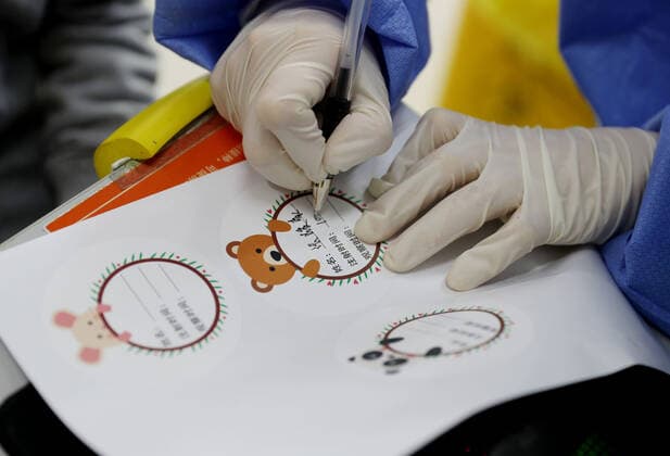 (211120) -- SHANGHAI, Nov. 20, 2021 -- A medical worker writes on an information card which is specially made for children at a vaccination site in Xuhui District of Shanghai, east China, Nov. 20, 2021. Shanghai started COVID-19 vaccination for children aged 3-5 from Saturday. ) CHINA-SHANGHAI-COVID-19-CHILDREN-VACCINATION (CN) LiuxYing 