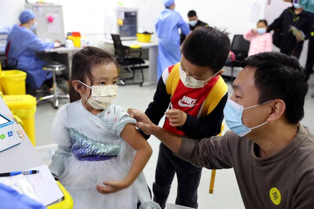 (211120) -- SHANGHAI, Nov. 20, 2021 -- A five-year-old girl, accompanied by her father and brother, gets vaccinated at a vaccination site in Xuhui District of Shanghai, east China, Nov. 20, 2021. Shanghai started COVID-19 vaccination for children aged 3-5 from Saturday. ) CHINA-SHANGHAI-COVID-19-CHILDREN-VACCINATION (CN) LiuxYing 