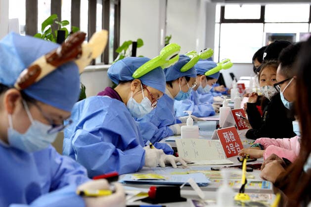 (211120) -- SHANGHAI, Nov. 20, 2021 -- Medical workers wearing cartoon head decorations work at a vaccination site in Xuhui District of Shanghai, east China, Nov. 20, 2021. Shanghai started COVID-19 vaccination for children aged 3-5 from Saturday. ) CHINA-SHANGHAI-COVID-19-CHILDREN-VACCINATION (CN) LiuxYing 