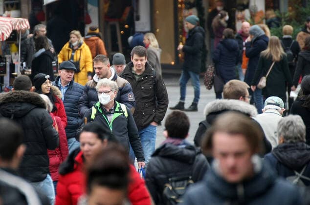 Ein Person trägt die Maske. Aufgrund der neuen Beschränkungen für das Coronavirus ist der Christkindlesmarkt 2021 abgesagt. Die Verkäufer bauen die Stände ab. during the Light Lockdown of the Covid 19 Coronavirus Pandemie in Nürnberg , Bayern, Deutschland . November 20, 2021.