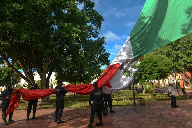 A Minimal Revolution Day Celebration In Valladolid Due To Covid-19 Pandemic Members of the municipal police (Policia Municipal de Valladolid) fold the national flag of Mexico after the short ceremony of El Dia de la Revolucion (Revolution Day), a national holiday commemorating the beginning of the Mexican Revolution on November 20, 1910. Official Revolution Day celebrations have been canceled due to the Covid-19 pandemic. The city of Valladolid was the site of the first spark of the Mexican Revolution, also known as the Dzelkoop Plan, an uprising that began on June 4, 1910, by Maximiliano R. Bonilla and other leaders of the Independent Electoral Center and the Anti Reelectionist Front, against the dictatorship of President Porfirio Dia  Copyright: xArturxWidakx widak-revoluti211120_npb5C