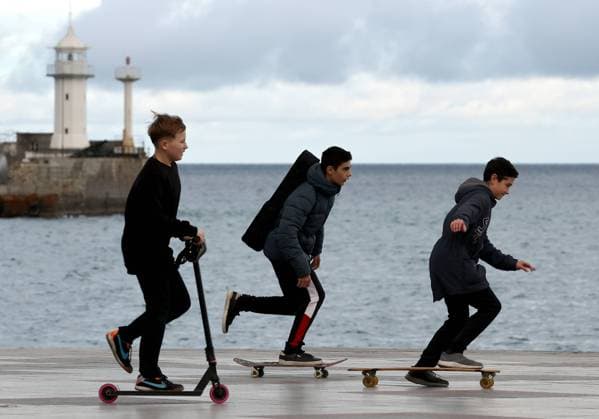 IMAGO Creative: Fit durch den Herbst YALTA, RUSSIA â€“ NOVEMBER 20, 2021: Teenagers ride skateboards and a kickscooter in a seafront area in the seaside resort of Yalta on Crimeaâ€™s Black Sea coast in late autumn. Sergei Malgavko TASS EDITORIAL USE ONLY; NO COMMERCIAL USE; NO ADVERTISING  TS118A15