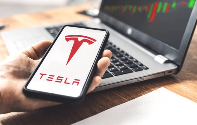 22 November 2021: Tesla car electric car logo on a smartphone, trading on the stock exchange with shares of Tesla stock by CEO Elon Musk, online trading with shares *** Tesla Auto Elektroauto Logo auf einem Smartphone, Handel an der Aktien Börse mit Anteilen der Tesla Aktie von Geschäftsführer Elon Musk, Online Trading mit Aktienanteilen xFOTOMONTAGEx