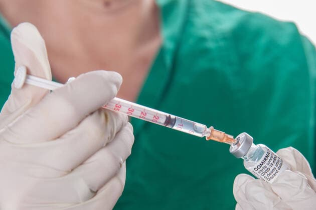 Bamberg, Germany 22 November 2021 A person wearing protective gloves drew up a vaccine dose with the mRNA vaccine Comirnaty, BNT162b2, Biontech Pfizer from an ampoule for primary vaccination secondary vaccination or booster vaccination against the coronavirus Covid 19 Bavaria with the help of a vaccination syringe. Copyright: xFotostandx xK.xSchmittx