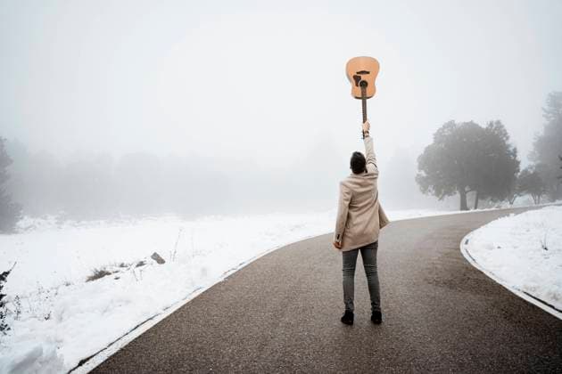 Mature man with hand raised holding guitar on road model released, RCPF01341
