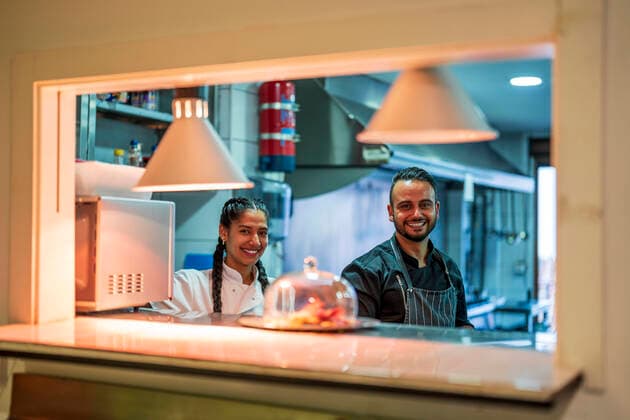 IMAGO Creative: Internationaler Frauentag, Gender Pay Gap, Frauen verdienen 18 Prozent weniger IMAGO Creative: Landleben - Essen Smiling chef and trainee in commercial kitchen at restaurant model released property released, DLTSF02398