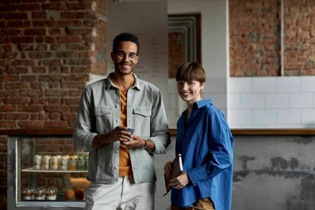 IMAGO Creative: Gesellschaft, Integration Smiling couple standing in modern cafe model released property released, DSHF00088