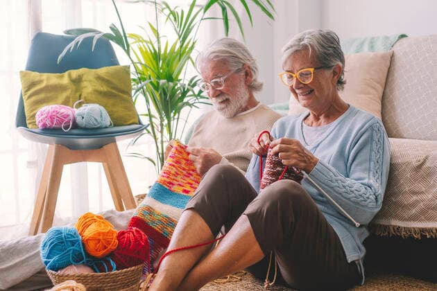 IMAGO Creative: Jahreszeit Winter, Couching Senior couple knitting wool in living room model released property released, SIPF02652