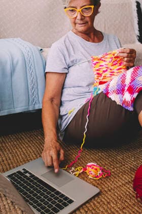 Woman with knitted wool using laptop at home model released property released, SIPF02690