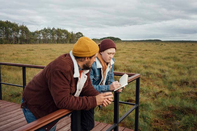 Man looking at son writing in diary while leaning on railing model released, VPIF05158