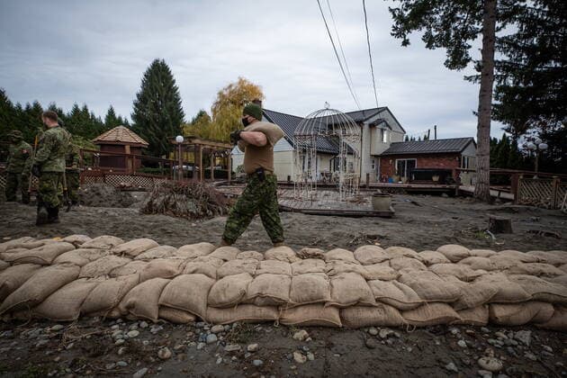 November 24, 2021, ABBOTSFORD, BC, CANADA: A member of the Canadian Forces carries sandbags as they build a temporary dike behind houses on Clayburn Creek ahead of a rainfall warning Environment Canada has forecast for the region which is already affected by flooding, in Abbotsford, B.C., on Wednesday, November 24, 2021. ABBOTSFORD CANADA  - ZUMAc35_ 20211124_zaf_c35_146 Copyright: xDarrylxDyckx