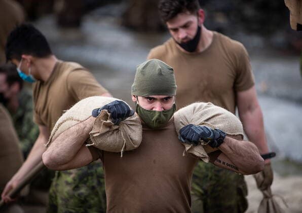 November 24, 2021, ABBOTSFORD, BC, CANADA: A member of the Canadian Forces carries sandbags as they build a temporary dike behind houses on Clayburn Creek ahead of a rainfall warning Environment Canada has forecast for the region which is already affected by flooding, in Abbotsford, B.C., on Wednesday, November 24, 2021. ABBOTSFORD CANADA  - ZUMAc35_ 20211124_zaf_c35_147 Copyright: xDarrylxDyckx