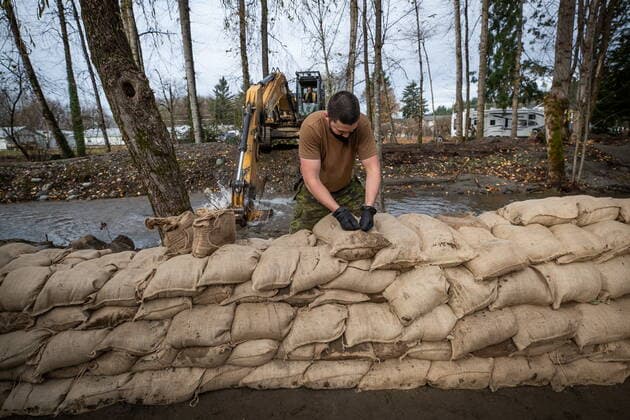 November 24, 2021, ABBOTSFORD, BC, CANADA: A member of the Canadian Forces builds a temporary dike with sandbags behind houses on Clayburn Creek ahead of a rainfall warning Environment Canada has forecast for the region which is already affected by flooding, in Abbotsford, B.C., on Wednesday, November 24, 2021. ABBOTSFORD CANADA  - ZUMAc35_ 20211124_zaf_c35_154 Copyright: xDarrylxDyckx