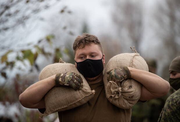 November 24, 2021, ABBOTSFORD, BC, CANADA: A member of the Canadian Forces carries sandbags as they create a temporary dike behind houses on Clayburn Creek ahead of a rainfall warning Environment Canada has forecast for the region which is already affected by flooding, in Abbotsford, B.C., on Wednesday, November 24, 2021. ABBOTSFORD CANADA  - ZUMAc35_ 20211124_zaf_c35_155 Copyright: xDarrylxDyckx