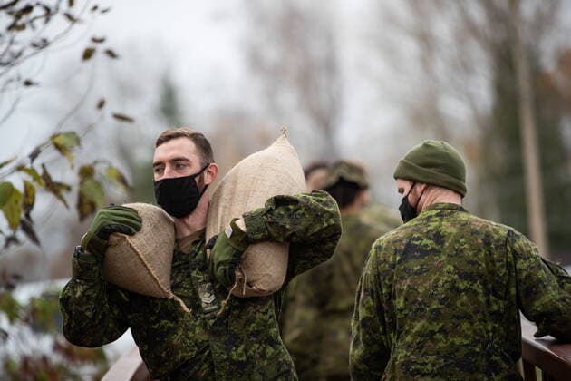 November 24, 2021, ABBOTSFORD, BC, CANADA: A member of the Canadian Forces carries sandbags as they create a temporary dike behind houses on Clayburn Creek ahead of a rainfall warning Environment Canada has forecast for the region which is already affected by flooding, in Abbotsford, B.C., on Wednesday, November 24, 2021. ABBOTSFORD CANADA  - ZUMAc35_ 20211124_zaf_c35_156 Copyright: xDarrylxDyckx