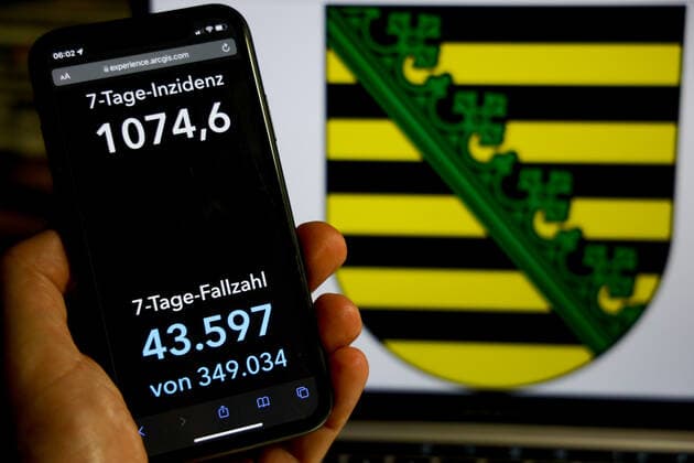 Coronavirus in Germany Covid 19 Dashboard of Robert Koch Institute Incidence in Saxony exceeds value of 1000 DEU, Germany, Saxony 25 11 2021 The 7-day incidence for the state Cases last 7 days 100 000 p.e. is displayed on an iPhone, with the state coat of arms in the background