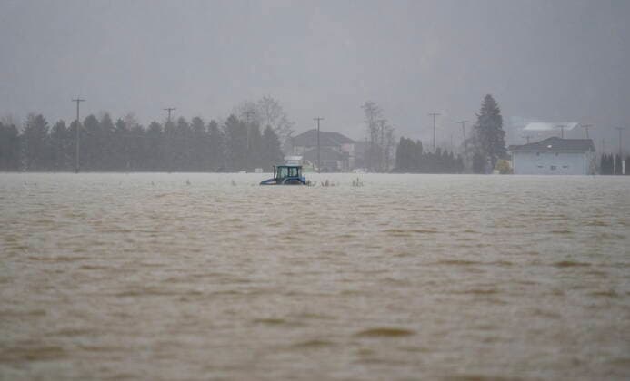 November 25, 2021, ABBOTSFORD, BC, CANADA: A tractor is pictured in a flooded field in Abbotsford, B.C., Thursday, November 25, 2021. ABBOTSFORD CANADA  - ZUMAc35_ 20211125_zaf_c35_121 Copyright: xJonathanxHaywardx