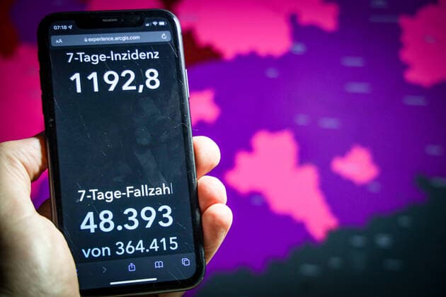 Coronavirus in Germany Covid 19 Dashboard of the Robert Koch Institute DEU, Germany, Saxony 26 11 2021 The 7-day incidence for the state Cases last 7 days 100 000 PE is displayed on an iPhone, with the state coat of arms in the background.