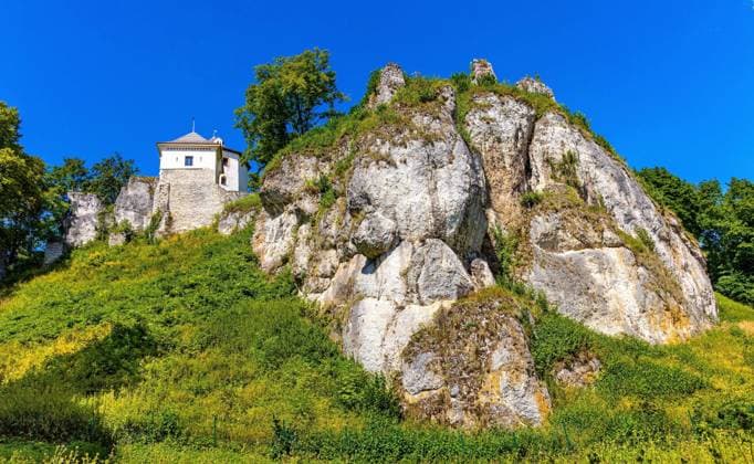 Ojcow, Poland - August 24, 2020: Limestone rocky defense walls and towers of medieval royal Ojcow Castle on Cracow-Czestochowa upland in Lesser Poland  BEW1DDB0ADE