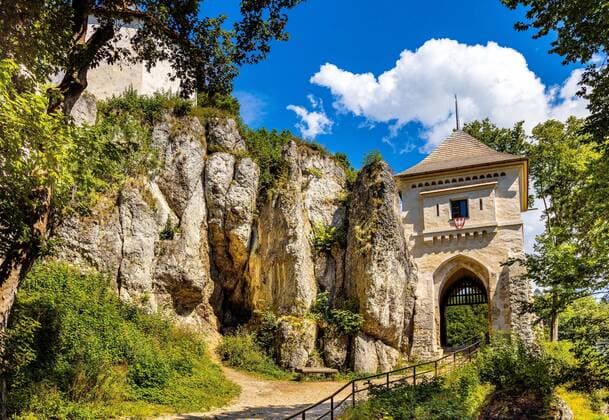 Ojcow, Poland - August 24, 2020: Gate tower and limestone rocky defense walls of medieval royal Ojcow Castle on Cracow-Czestochowa upland in Lesser Poland  BEW1DDB0B43