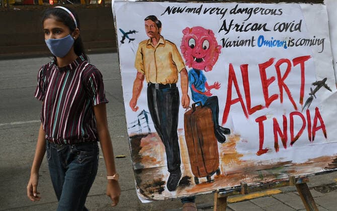 News Bilder des Tages November 27, 2021, Mumbai, Maharashtra, India: A girl wearing a protective face mask walks past a painting made by Gurukul school of art to create awareness about the new variant of coronavirus which has emerged in South Africa..Brihanmumbai Municipal Corporation (BMC) as a precautionary measure will quarantine South Africa returnees on arrival in Mumbai. Mumbai India - ZUMAs197 20211127_zaa_s197_055 Copyright: xAshishxVaishnavx