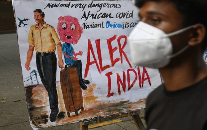 November 27, 2021, Mumbai, Maharashtra, India: A man wearing a protective face mask walks past a painting made by Gurukul school of art to create awareness about the new variant of coronavirus which has emerged in South Africa..Brihanmumbai Municipal Corporation (BMC) as a precautionary measure will quarantine South Africa returnees on arrival in Mumbai. Mumbai India - ZUMAs197 20211127_zaa_s197_054 Copyright: xAshishxVaishnavx