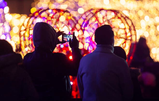 (211128) -- TORONTO, Nov. 28, 2021 -- A man takes photos during the 2021 Cavalcade of Lights in Toronto, Canada, Nov. 27, 2021. The annual light show in Toronto kicked off on Saturday and will last until Jan. 2, 2022. (Photo by Xinhua) CANADA-TORONTO-LIGHT SHOW ZouxZheng 