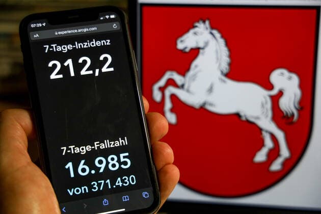 Coronavirus in Germany Covid 19 Dashboard of the Robert Koch Institute DEU, Germany, Lower Saxony 28 11 2021 The 7-day incidence for the state Cases last 7 days 100 000 p.e. is displayed on an iPhone, with the state coat of arms in the background