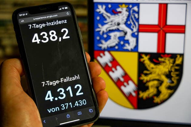 Coronavirus in Germany Covid 19 Dashboard of the Robert Koch Institute DEU, Germany, Saarland 28 11 2021 The 7-day incidence for the state Cases last 7 days 100 000 PE is displayed on an iPhone, with the state coat of arms in the background.