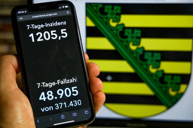 Coronavirus in Germany Covid 19 Dashboard of the Robert Koch Institute DEU, Germany, Saxony 28 11 2021 The 7-day incidence for the state Cases last 7 days 100 000 PE is displayed on an iPhone, with the state coat of arms in the background.