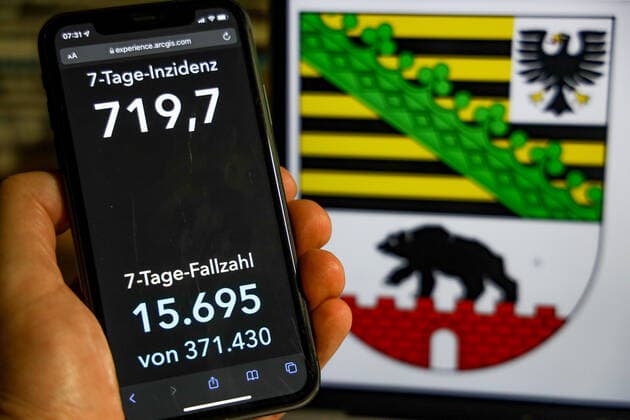 Coronavirus in Germany Covid 19 Dashboard of the Robert Koch Institute DEU, Germany, Saxony Anhalt 28 11 2021 The 7-day incidence for the state Cases last 7 days 100 000 p.e. is displayed on an iPhone, with the state coat of arms in the background