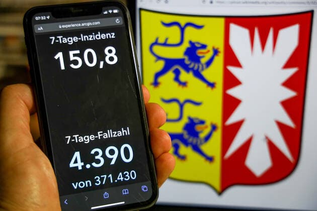Coronavirus in Germany Covid 19 Dashboard of the Robert Koch Institute DEU, Germany, Schleswig Holstein 28 11 2021 The 7-day incidence for the state Cases last 7 days 100 000 p.e. is displayed on an iPhone, with the state coat of arms in the background