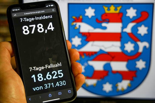 Coronavirus in Germany Covid 19 Dashboard of the Robert Koch Institute DEU, Germany, Thuringia 28 11 2021 The 7-day incidence for the state Cases last 7 days 100 000 p.e. is displayed on an iPhone, with the state coat of arms in the background