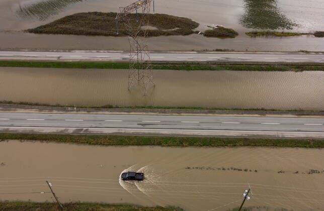 December 1, 2021, ABBOTSFORD, BC, CANADA: A motorist drives on a service road along the closed Trans-Canada Highway as floodwaters fill the ditches beside the highway and farmland in Abbotsford, B.C., on Wednesday, December 1, 2021. ABBOTSFORD CANADA  - ZUMAc35_ 20211201_zaf_c35_099 Copyright: xDarrylxDyckx