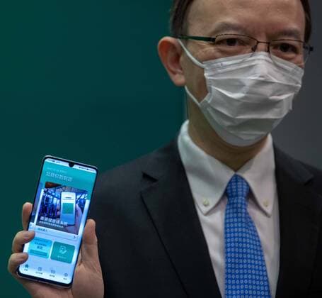 HONG KONG, CHINA - DECEMBER 02: Victor Lam Wai-kiu,Hong Kong Government Chief Information Officer, holds a smartphone displaying a new COVID-19 tracking health code app system at a news conference on December 2, 2021 in Hong Kong, China.  Copyright: xVCGx CFP111360090937