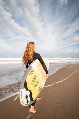 Creative Highlights Symbolbilder Full body back view of sportive female surfer in black wetsuit walking on wet shore near waving sea during training, Model released LeoPastor_BlondeWomanSurf_058.jpg Copyright: xLeoxPastorx MR