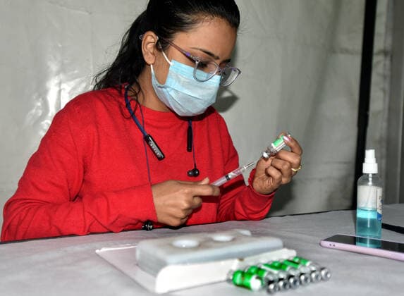 NEW DELHI, INDIA - DECEMBER 2: A health worker prepares a dose of Covid-19 vaccine during a special vaccination camp organised after Omicron Covid Variant identified at Anand Vihar Railway Station, on December 2, 2021 in New Delhi, India. (Photo by Sonu Mehta Hindustan Times) Daily Life Amid Coronavirus Pandemic In India