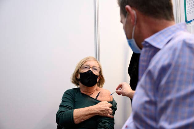 Prime Minister Mette Frederiksen S puts on plasters and directors of the National Board of Health Soeren Brostroem vaccinates when they visit covid 19 vaccination site in the old ticket office at Copenhagen Central Station, Friday 3 December 2021 The Prime Minister and Soere  Copyright: PhilipxDavali PhilipxDavalix cop105 spdk20211203-161036-L