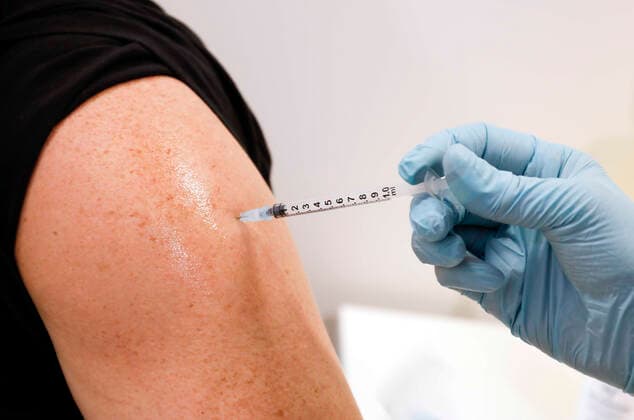 Vaccinations Schoenefeld, 03 12 2021 A man receives a booster vaccination of Moderna against Covid 19 in the vaccination center Schoenefeld Schoenefeld Brandenburg