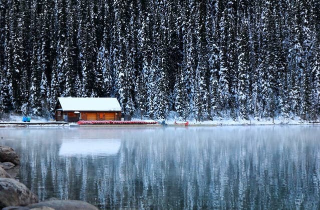 A small wooden cabin shrouded by evergreens on the tranquil shores of Lake Louise rents canoes, Alberta, Canada. Lake Louise Alberta Canada Copyright: xChuckxDavidx xVWPicsx CHD043A8192Lake Louise